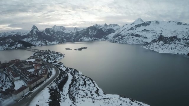 Lake in winter with snow and village