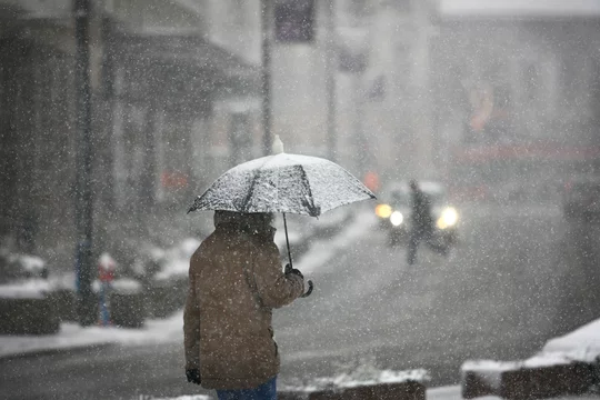 Man with umbrella during snow storm