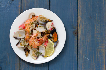 seafood salad on plate on blue wooden background
