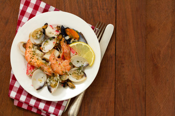 seafood salad on plate on brown wooden background