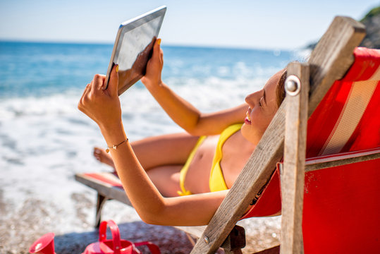 Woman making selfie with digital tablet on the beach