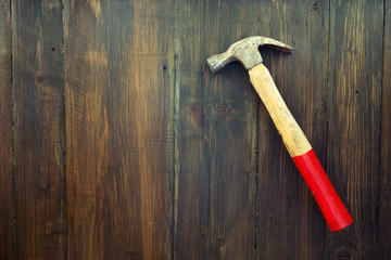 Old hammer on wooden background