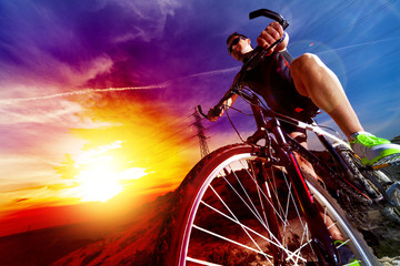 Deporte y vida saludable. Bicicleta de montaña y puesta del sol. - obrazy, fototapety, plakaty
