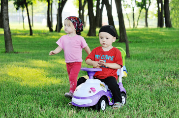 Fototapeta premium little boy and girl on a toy car