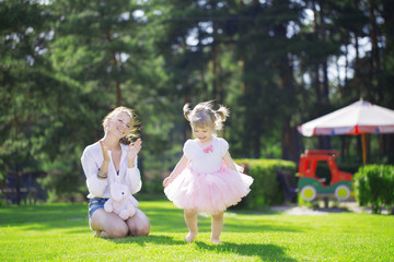 Naklejka premium Smiling girl applauds baby