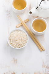 rice, green tea and chopsticks for sushi on white 