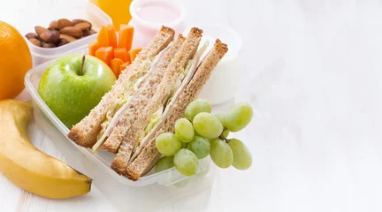 Fotobehang Assortiment school lunch with sandwiches and fruit on white background