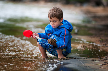 young boy playing in the sand at the beach