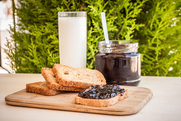 breakfast with sour cherry marmalade on toast with a glass of milk and frutis