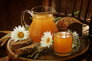 Kvass (Kvas) in a transparent mug, a jug and rye bread