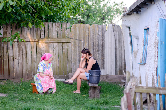 Woman Talking with Mother Outdoors in Yard
