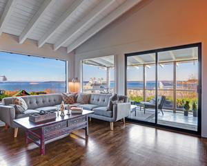 Living room with water view and large grey modern sofa.