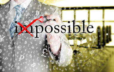Businessman Hand turning the word Impossible into Possible with