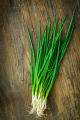 Young green onions on a wooden board