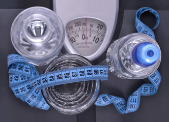 Bottles of water, glass of water and measuring tape