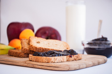 breakfast with sour cherry marmalade on toast with a glass of milk and frutis