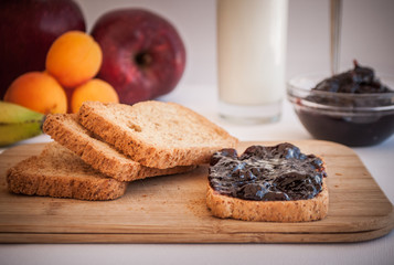 breakfast with sour cherry marmalade on toast with a glass of milk and frutis