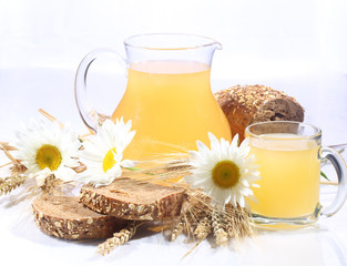 Kvass (Kvas) in a transparent mug, a jug and rye bread on a whit