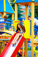 group of happy kids sliding in colorful playground