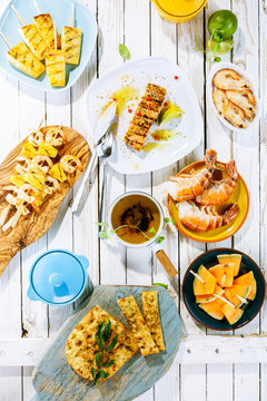 Grilled Fruit And Seafood Dishes On Rustic Table