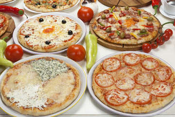 Several kinds of pizza served on the table.