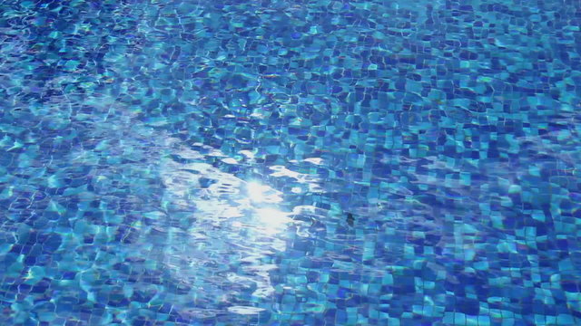 Sunlight reflection in blue water, pool surface ripple, vacation