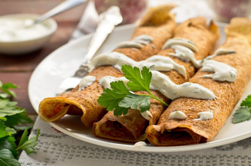 Pancake rolls with mushrooms and yogurt dip