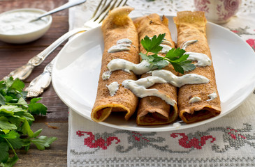 Pancake rolls with mushrooms and yogurt dip