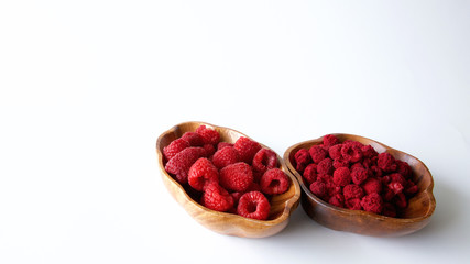 Fresh and dehydrated raspberry in wooden bowl 