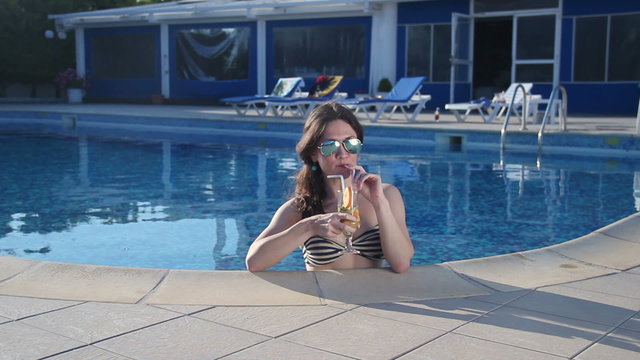 Beautiful woman in bikini drinking cocktail, enjoying hot summer
