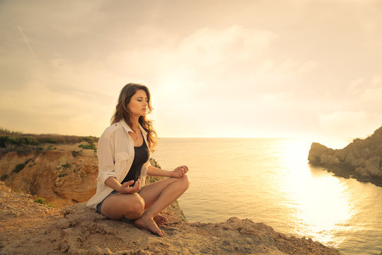 Young woman meditating at the seaside