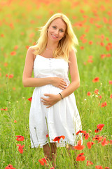  enceintes femme heureuse dans un champ de pavot floraison 