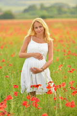  enceintes femme heureuse dans un champ de pavot floraison 