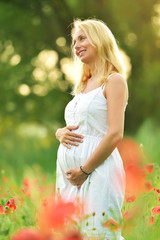 enceintes femme heureuse dans un champ de pavot floraison 