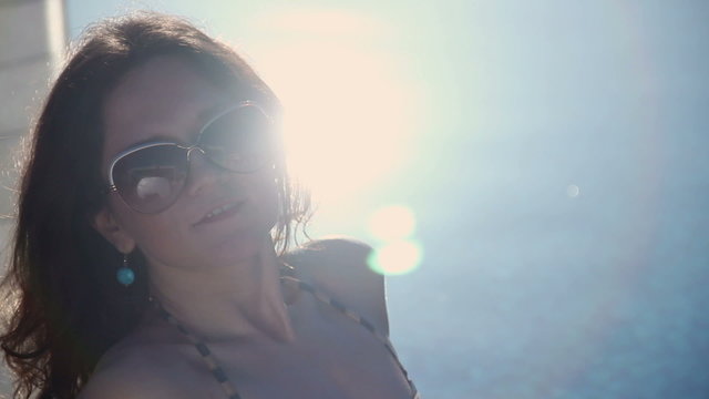 Beautiful woman enjoying sunlight on beach, smiling at camera