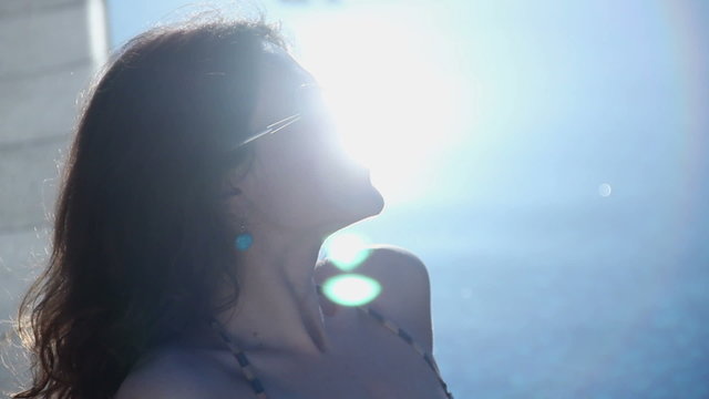 Happy female relaxing on beach, enjoying sunlight, light flare