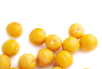 Pile of multiple yellow plums isolated