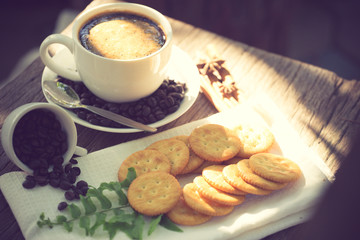 Cup of coffee on a wooden board and biscuits