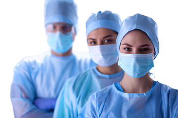 Surgeons team, wearing protective uniforms,caps and masks 