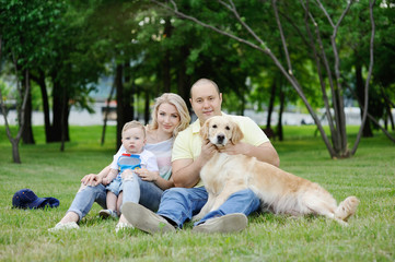 family with a dog retriever on the grass