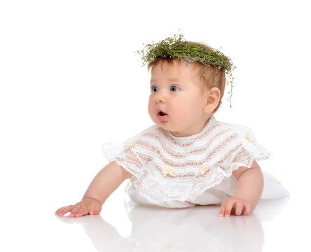 Infant child baby girl in diaper lying happy in circlet of flowe