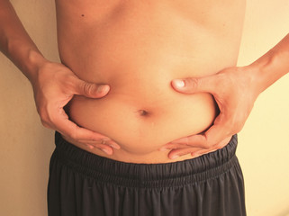 Naklejka premium Man is holding his too fat tummy