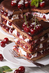 Sliced cherry cake with chocolate and cream close-up
