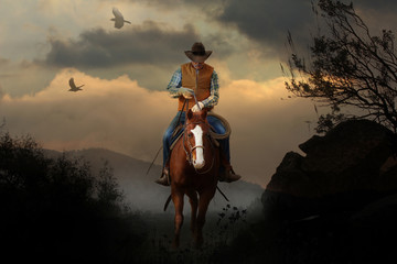 A mountain cowboy rides to the peak of a mountain with a beautiful cloudy sunset in the background...