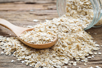 Rolled oat flakes oatmeal on old wooden table