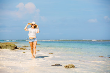 Fototapeta na wymiar Young skinny caucasian girl at the beach with blue sky on