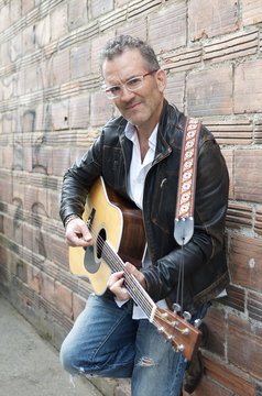 Portrait of Man in Alley playing the Guitar