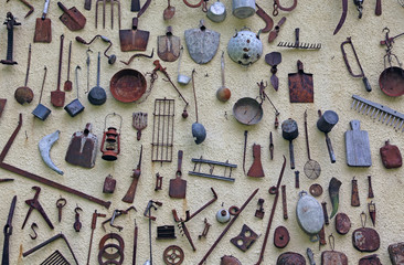 ancient farming tools hanging on the wall of the rural House