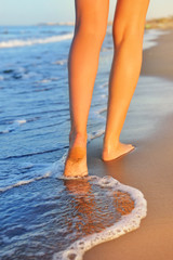Beautiful woman legs, walking on the beach