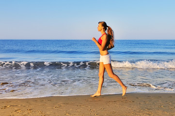 Beautiful girl running on beach at morning